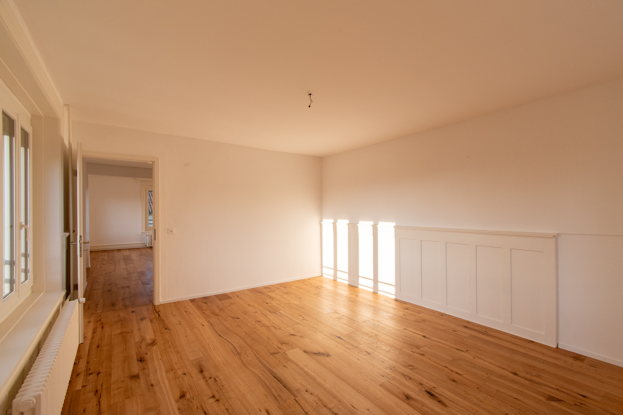 Helles, leeres Zimmer mit Holzboden