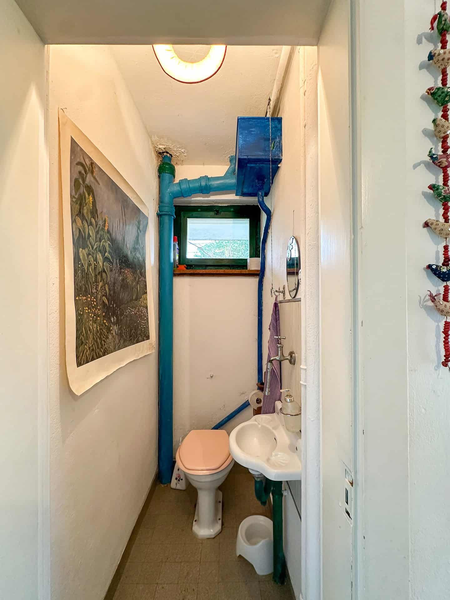 Kleines WC mit sichtbarer Rohrinstallation