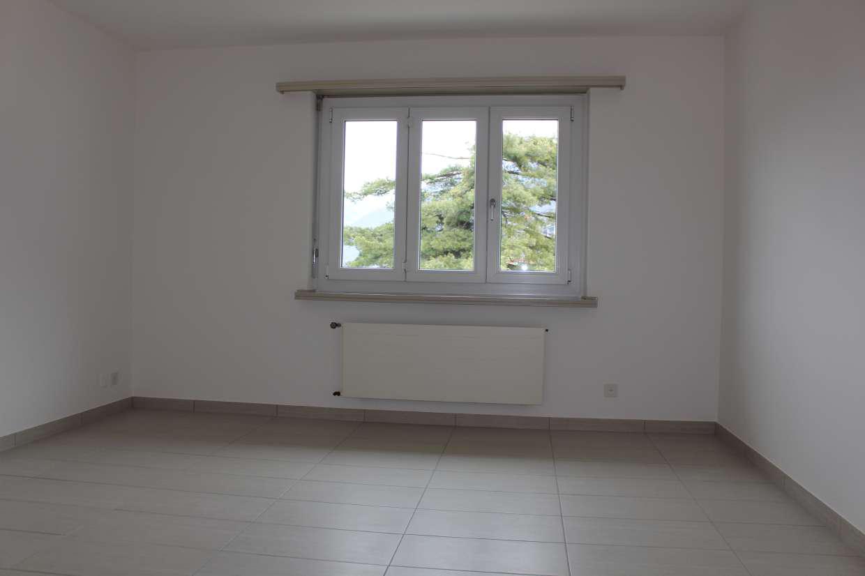 Leerer heller Raum mit Fenster und Heizkörper