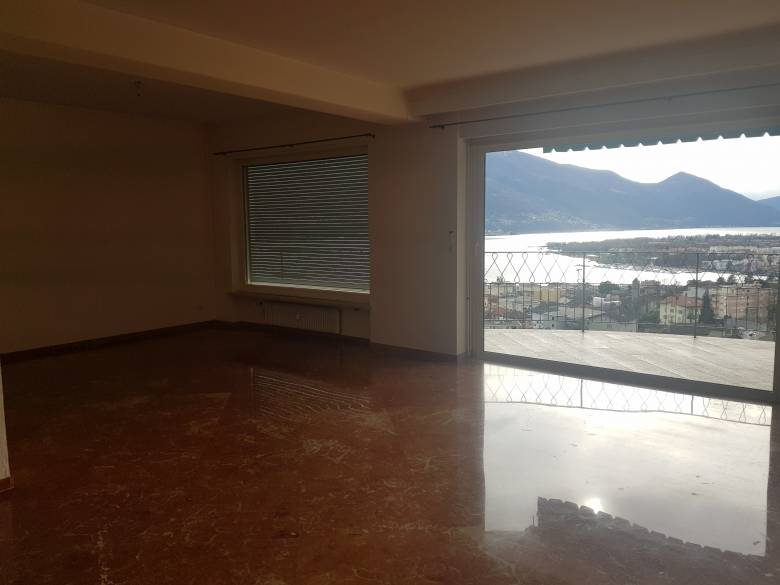 Leerer Wohnraum mit Balkon- und Seeblick