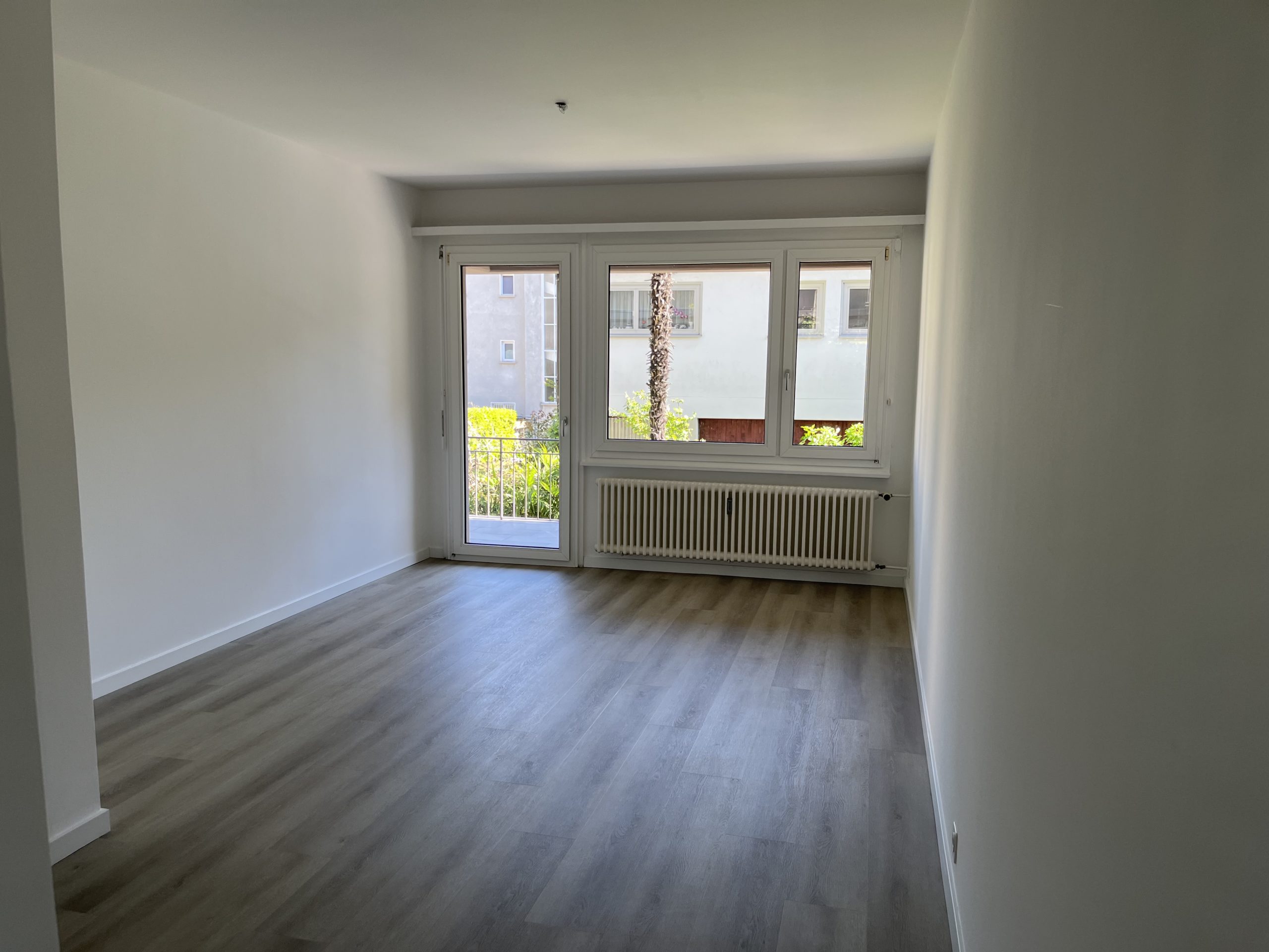 Leerer heller Wohnraum mit Balkonblick