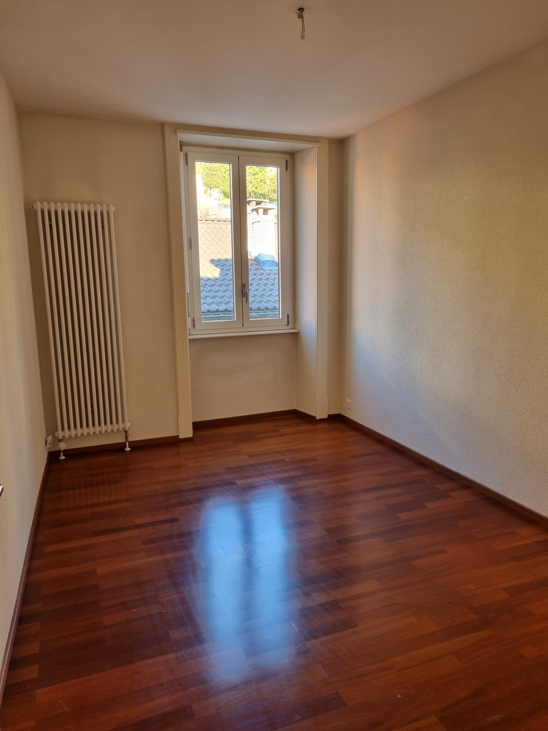 Leerer Wohnraum mit Fenster und Heizkörper
