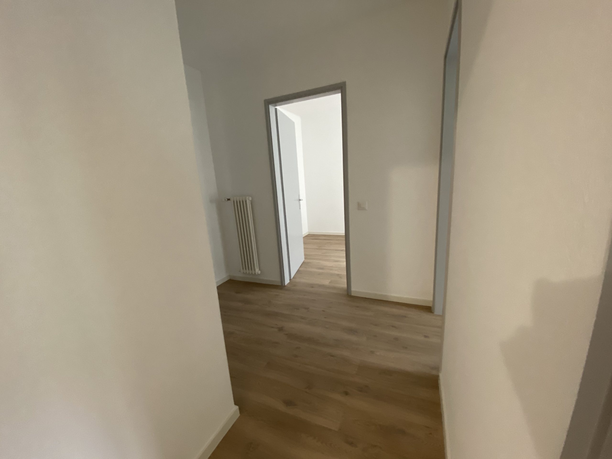 Flur mit Holzfußboden und offenen Durchgängen