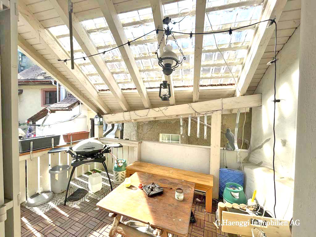 Überdachte Terrasse mit Grill und Sitzbereich