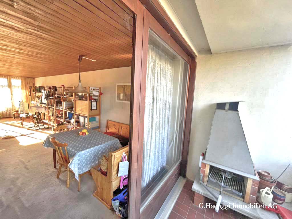 Überdachter Balkon mit Wohnbereich und Kamin