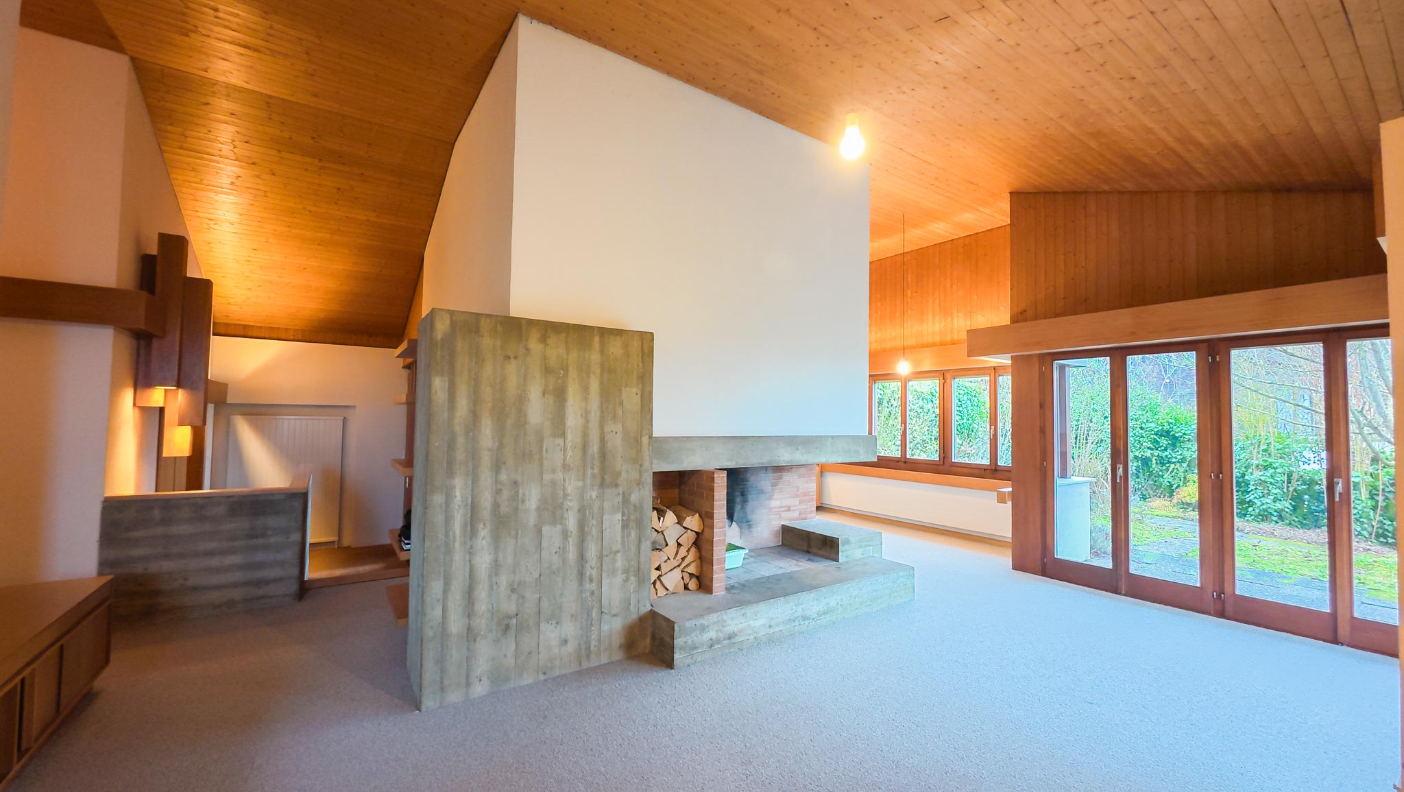 Wohnraum mit Kamin und Holzdecke