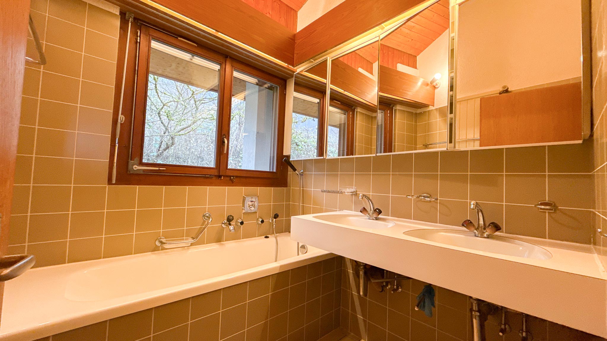 Badezimmer mit Holzdecke und Doppelwaschtisch