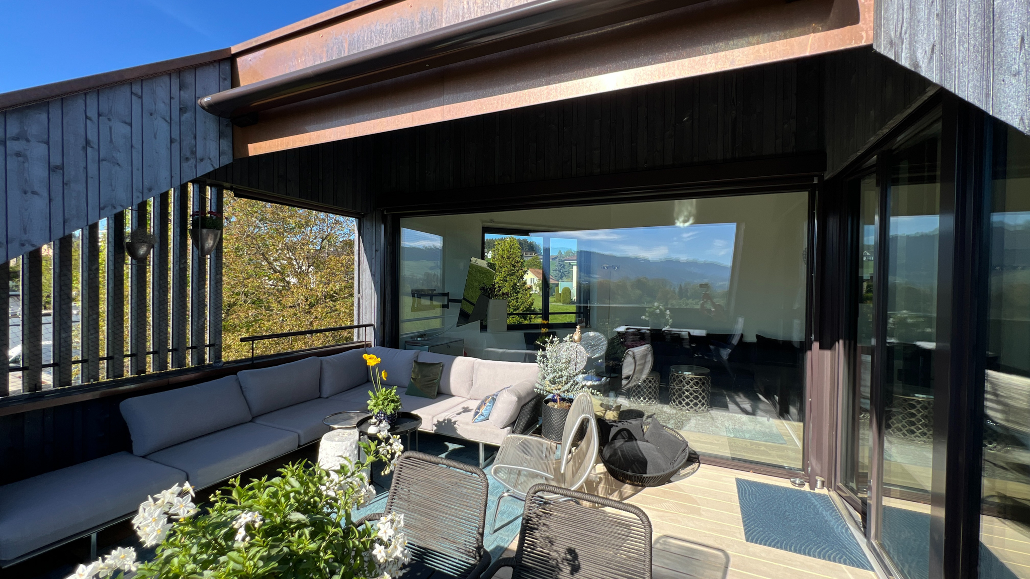 Moderne Dachterrasse mit Lounge-Möbeln und Bergblick