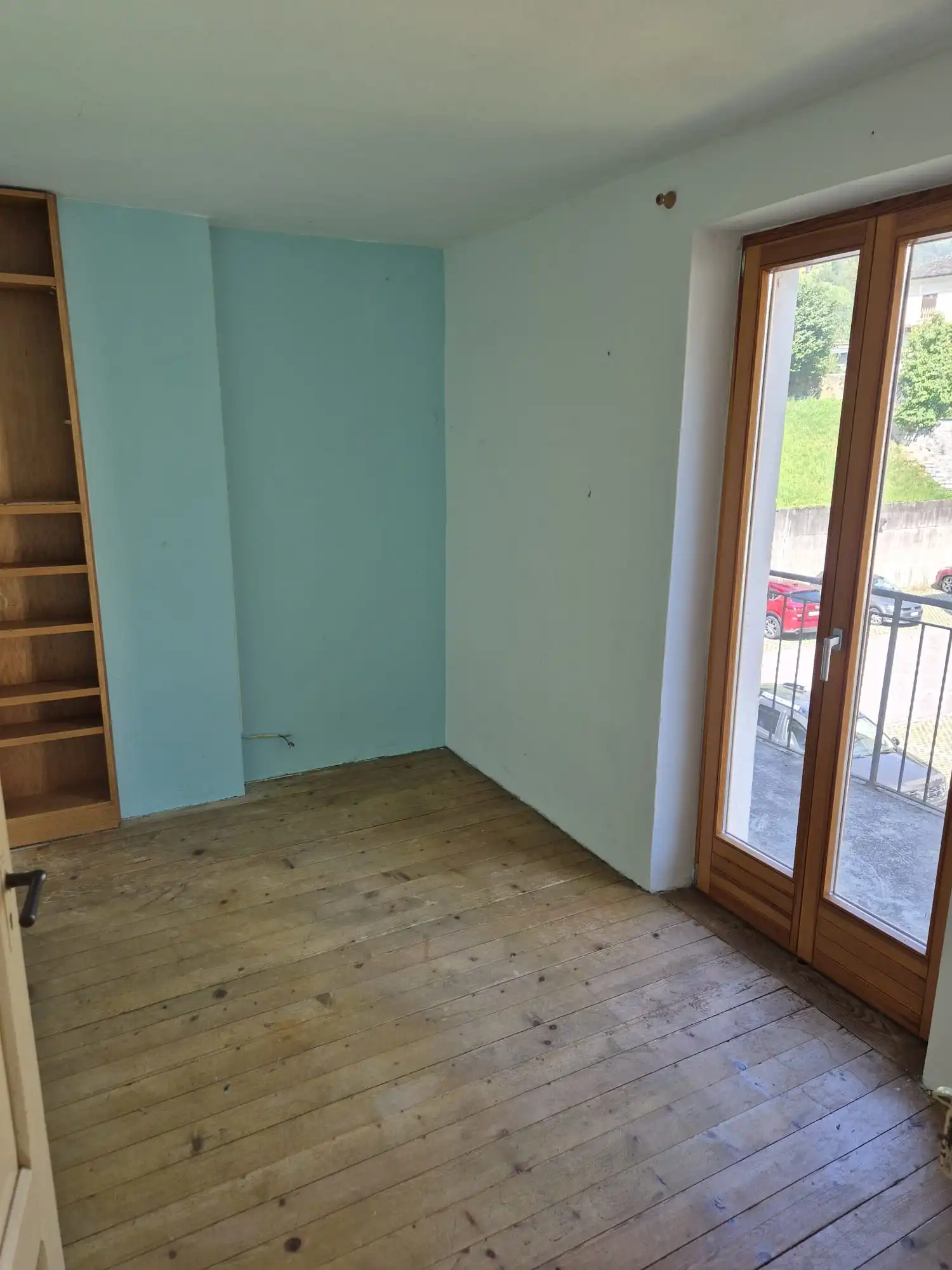 Leeres Zimmer mit Holzdielen und Balkontür