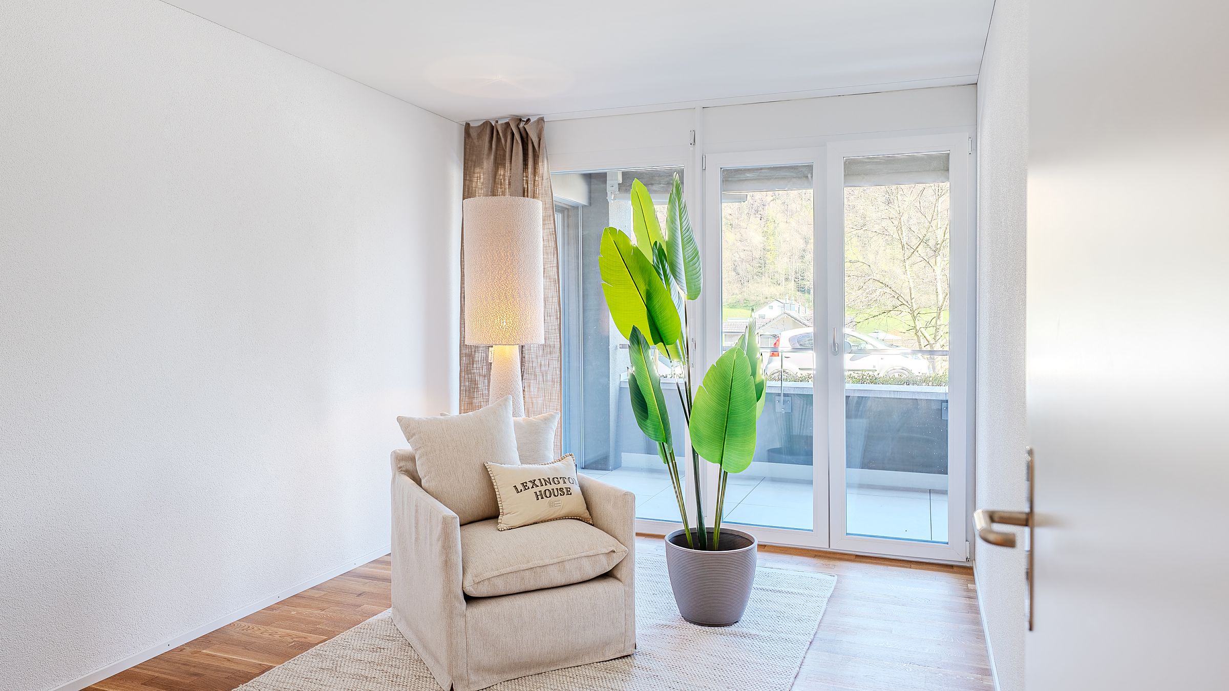 Helles, minimalistisch eingerichtetes Zimmer mit Balkonzugang