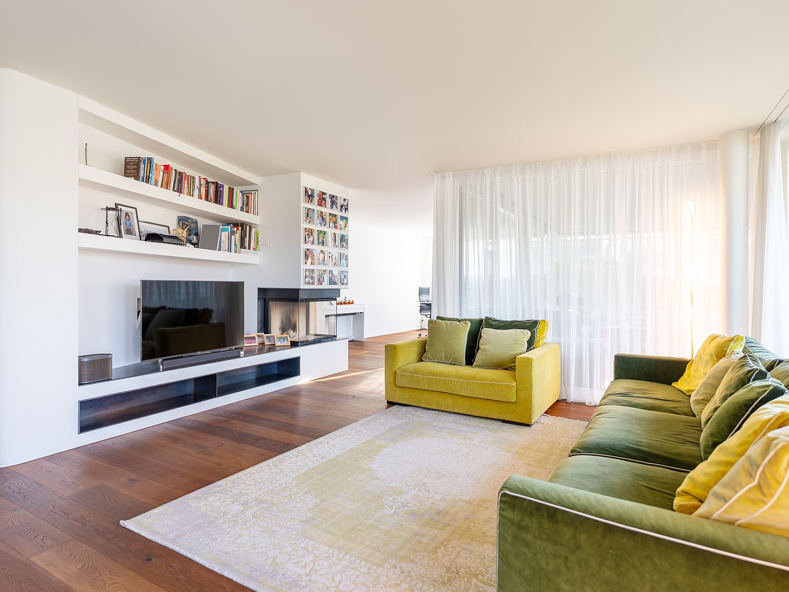 Helles Wohnzimmer mit Kamin, Regalen und großen Sitzmöbeln