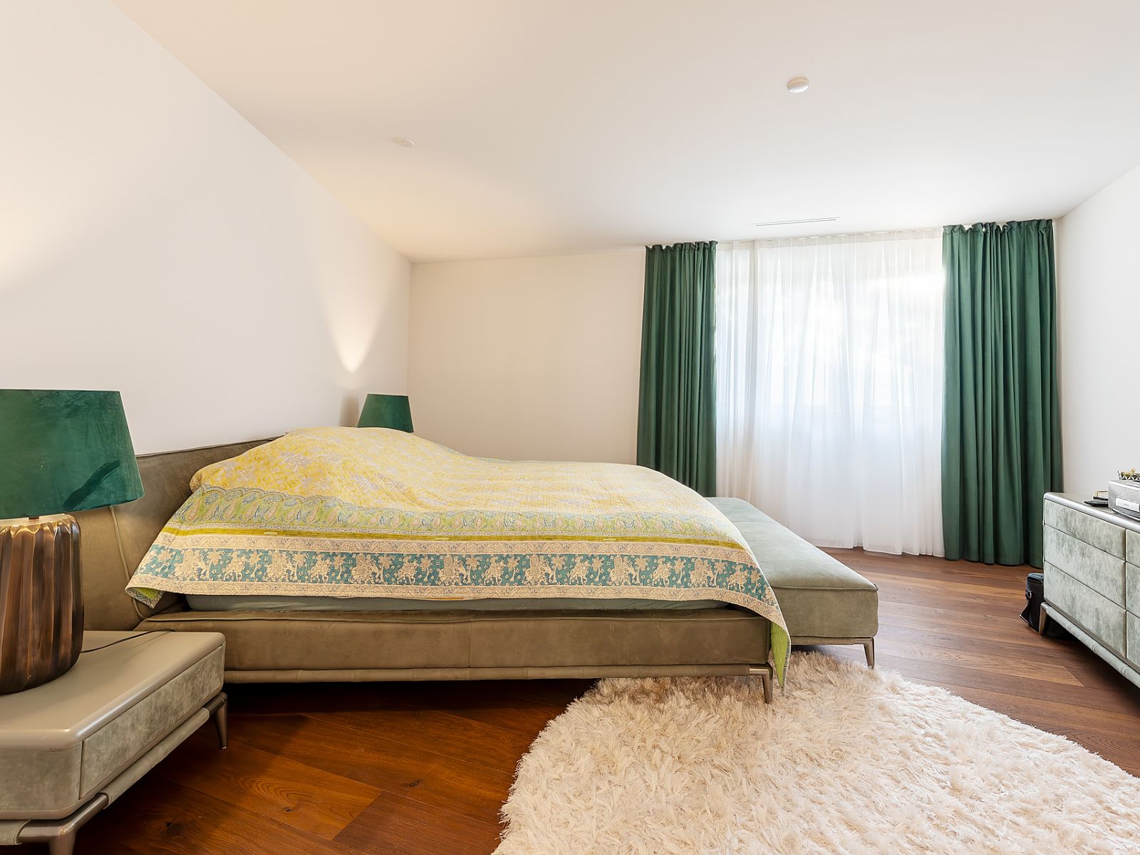 Helles Schlafzimmer mit grünem Akzentdekor