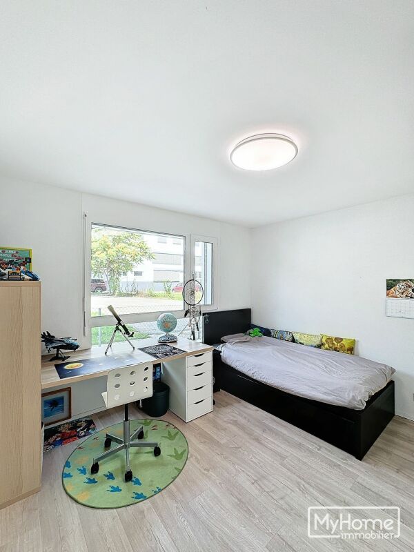 Helles Kinderzimmer mit Bett und Schreibtisch
