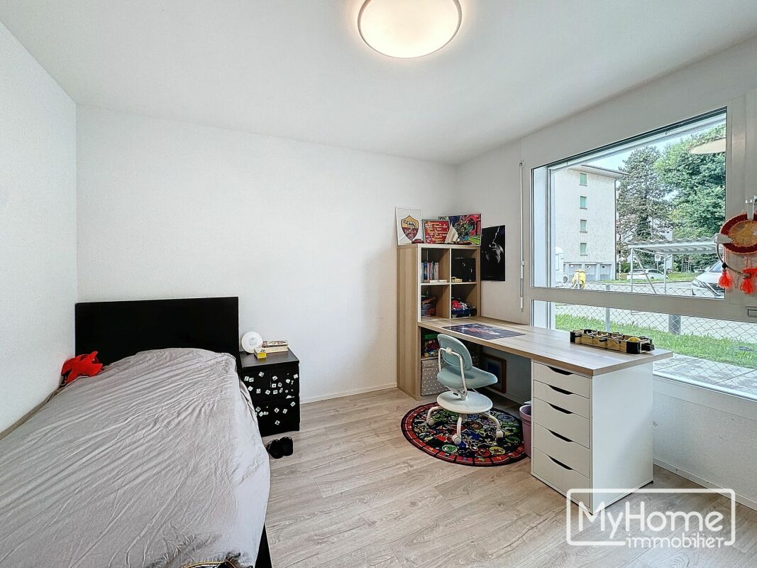 Kinderzimmer mit Schreibtisch und Bett