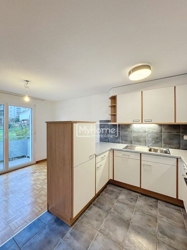 Kompakte Einbauküche mit Blick ins angrenzende Zimmer