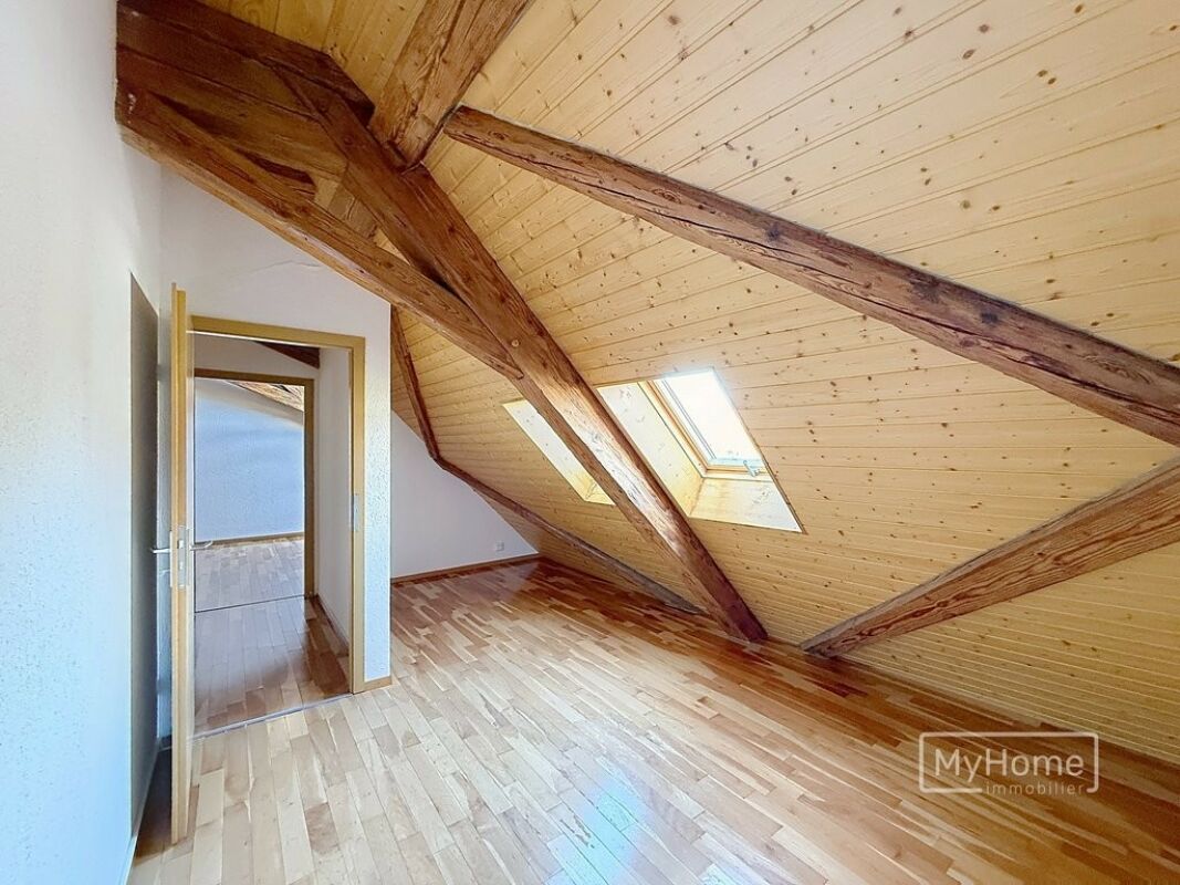Dachzimmer mit Sichtbalken und Dachfenster