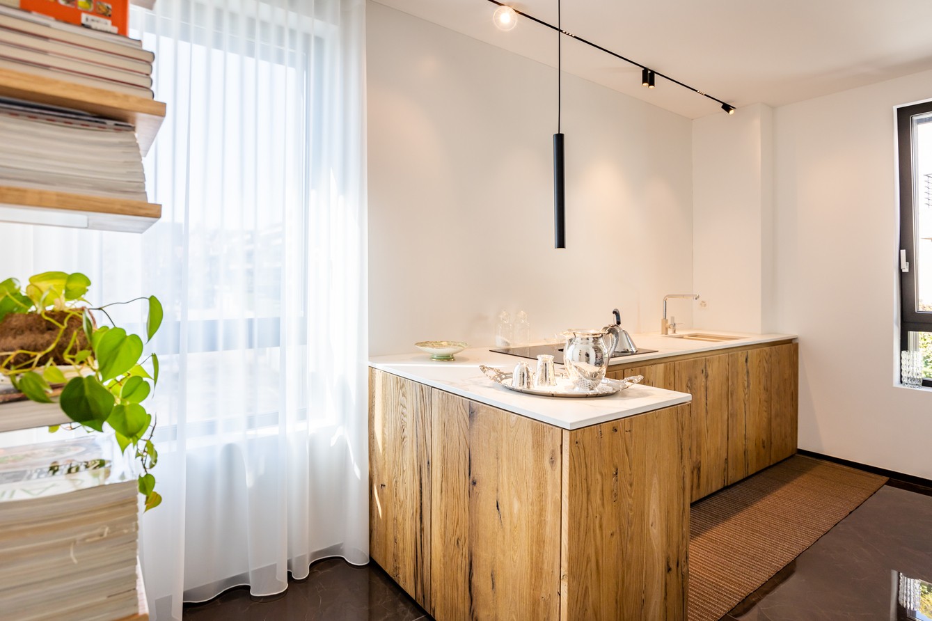 Helle Küche mit Holzfronten und schwarzer Pendelleuchte