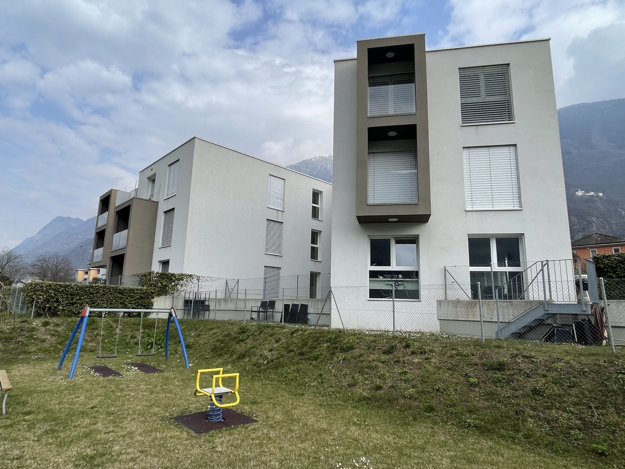 Moderner Wohnungsbau mit Spielbereich im Gemeinschaftsgarten