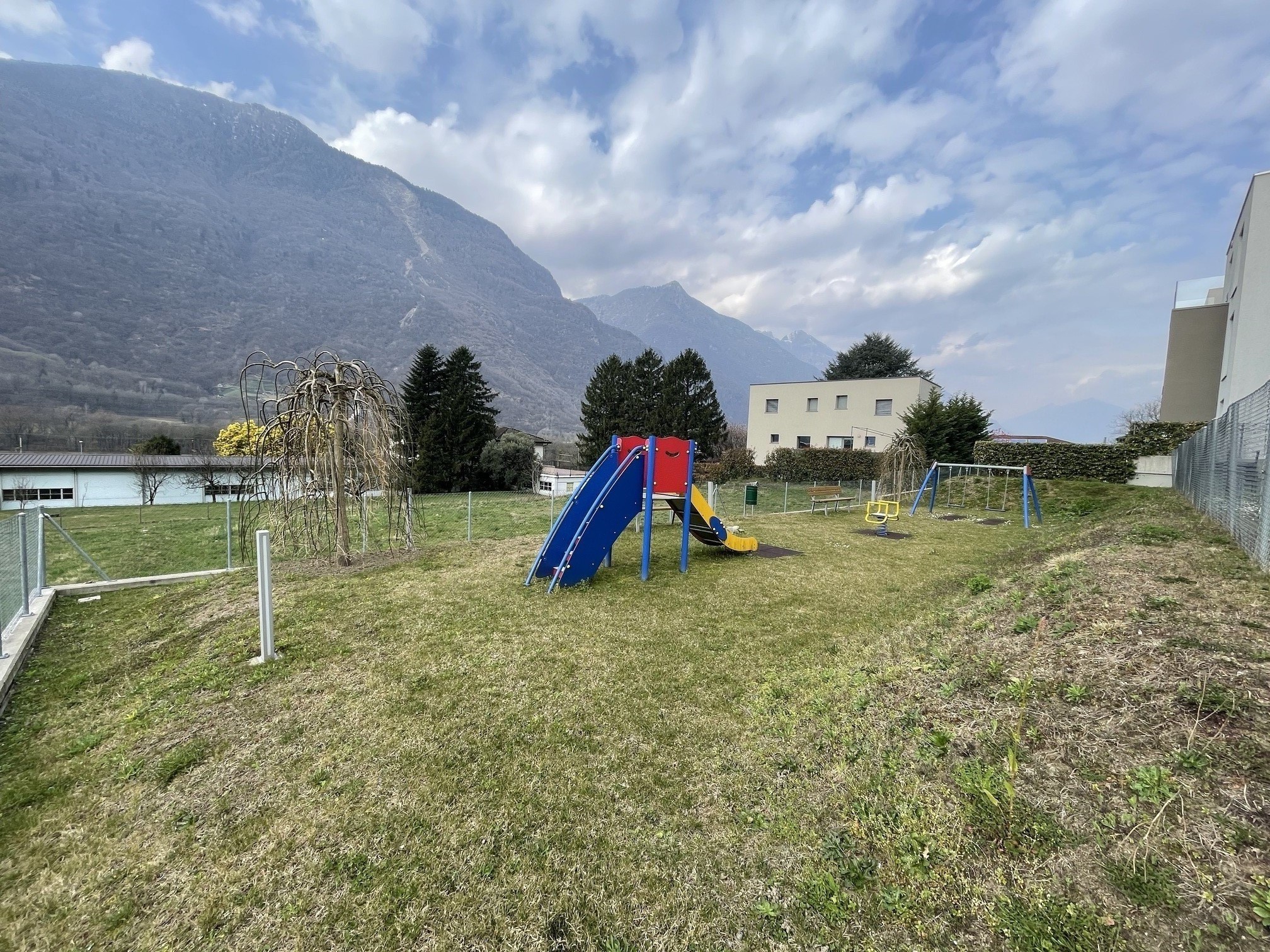 Außenbereich mit Spielplatz und Bergkulisse