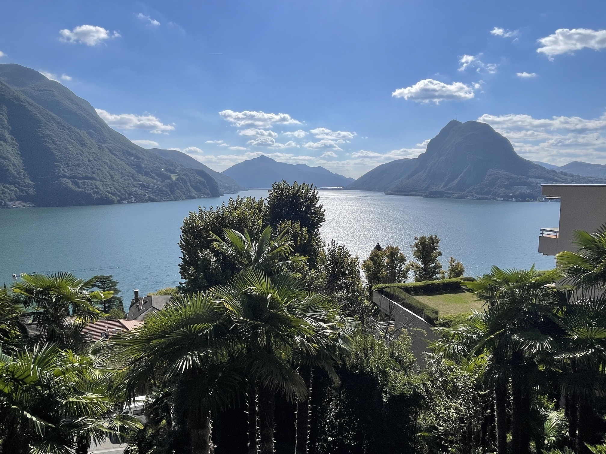 Panoramablick über einen See auf Berge und üppige Vegetation
