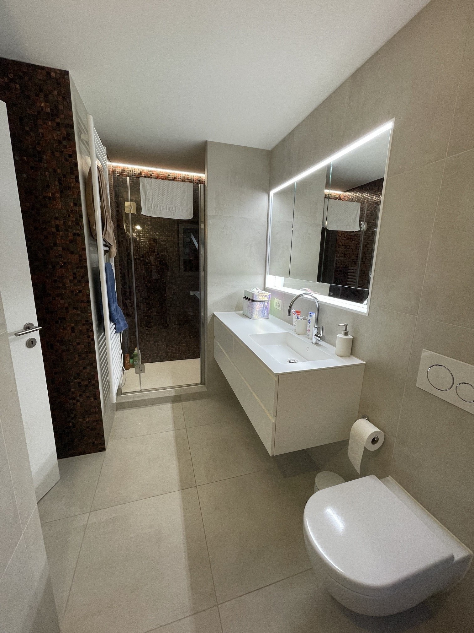 Modernes Badezimmer mit LED-Spiegel und bodengleicher Dusche