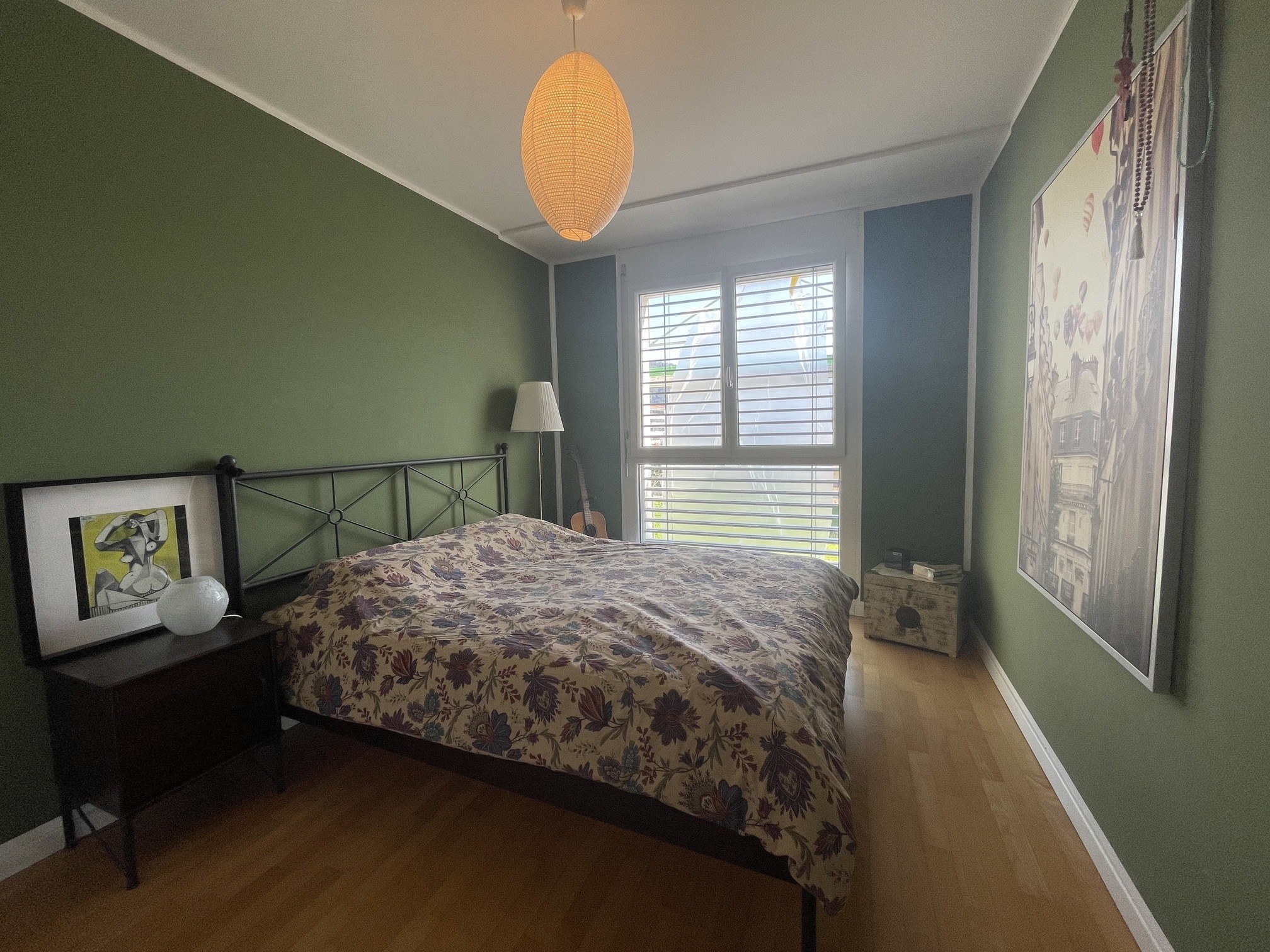 Gemütliches Schlafzimmer mit grün gestrichenen Wänden und Tageslicht