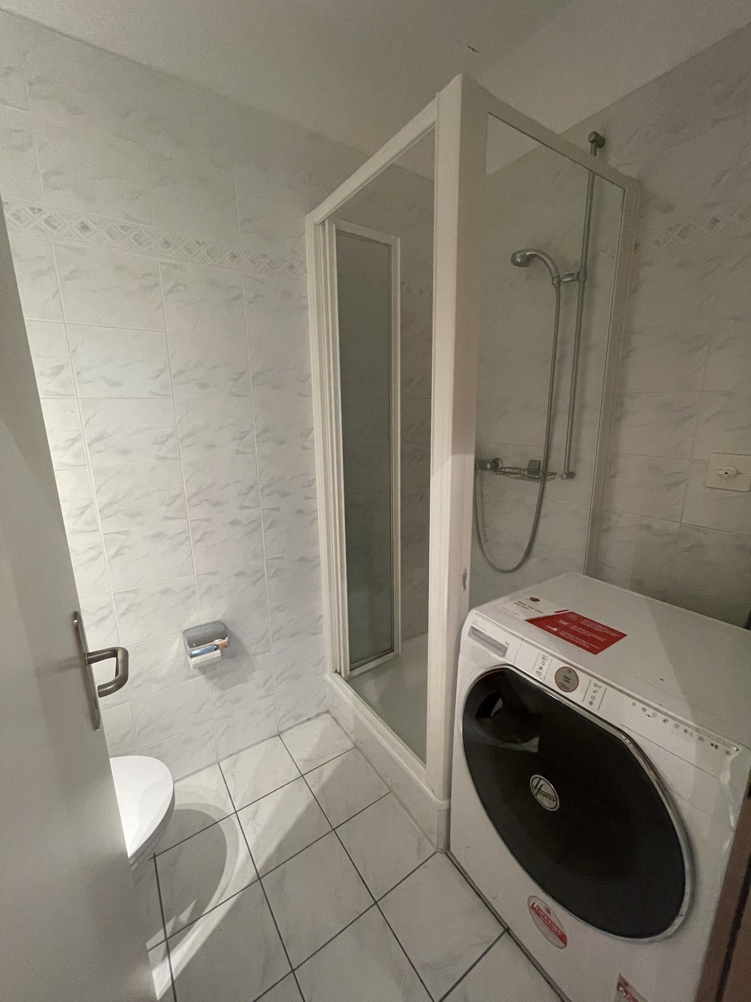 Badezimmer mit Dusche und Waschmaschine