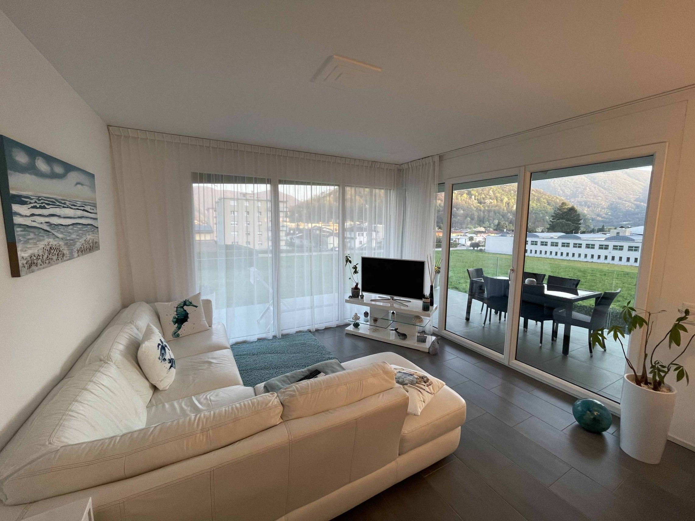 Helles Wohnzimmer mit Terrasse und Bergblick