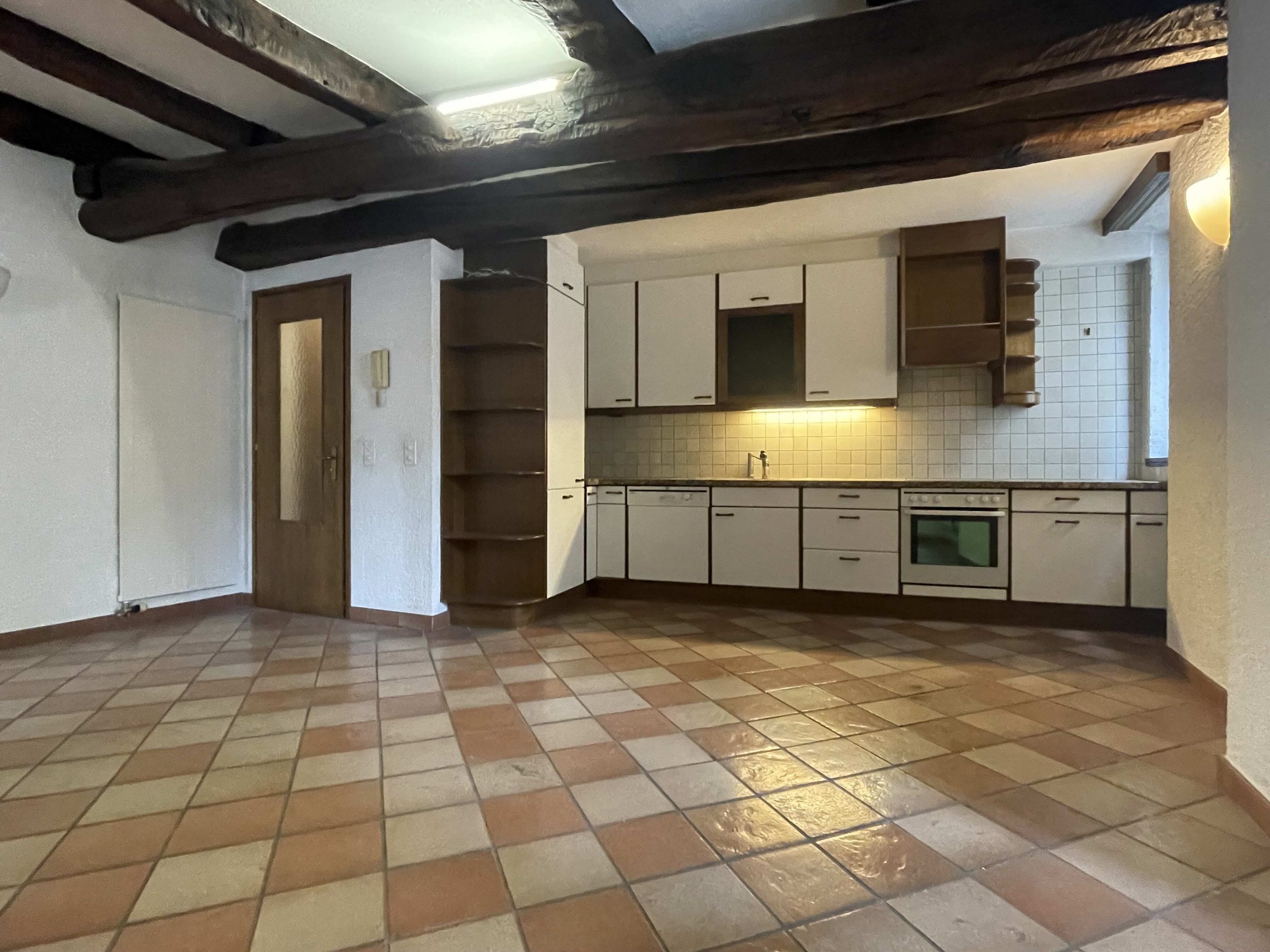 Rustikale Küche mit Terrakottafliesen und sichtbaren Holzbalken