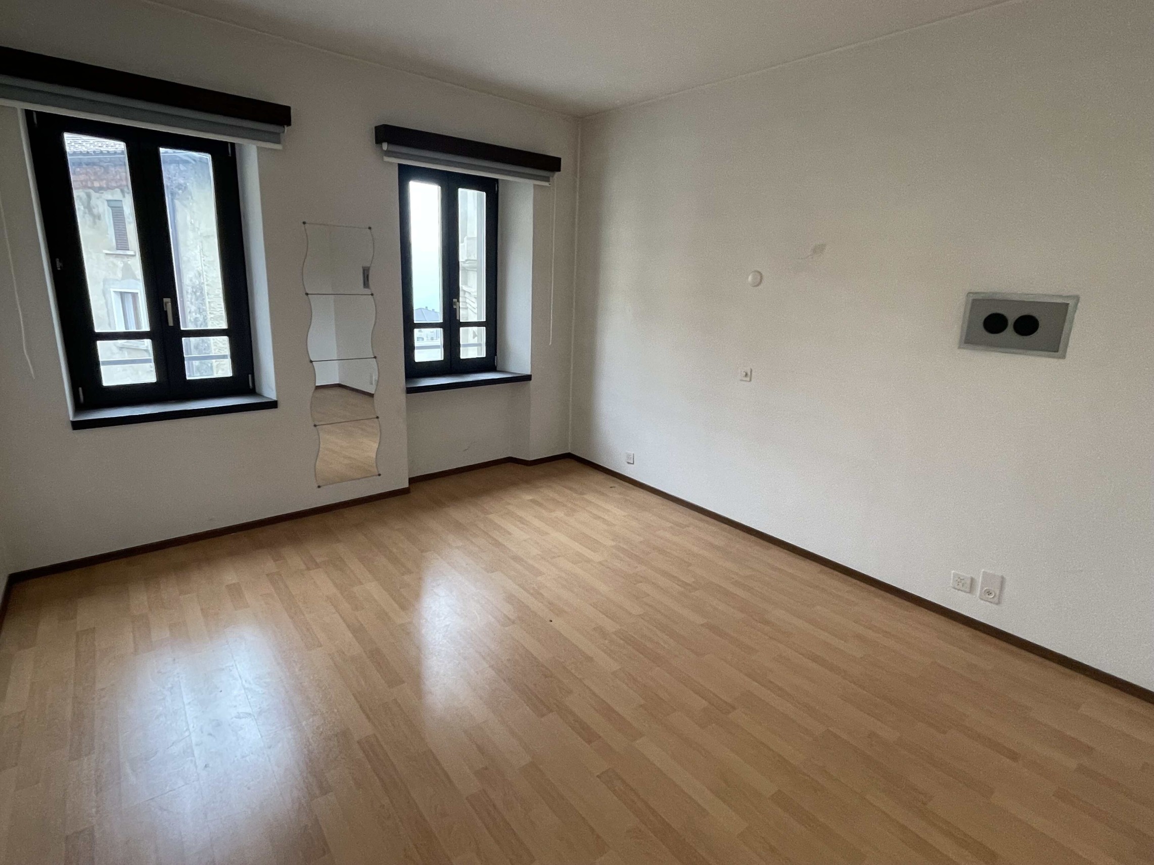 Leerer, heller Wohnraum mit zwei Fenstern