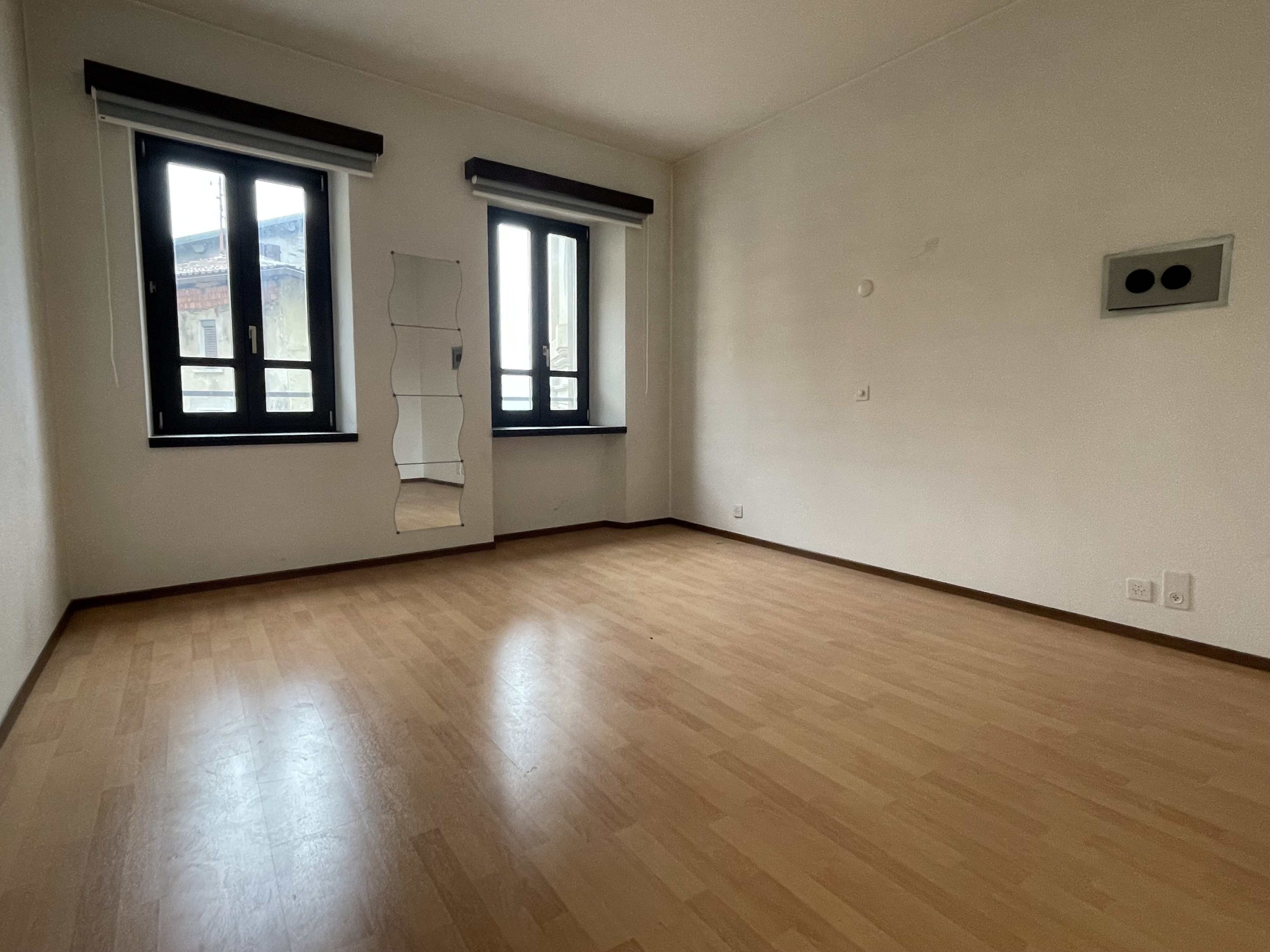 Leeres, modern wirkendes Zimmer mit zwei Fenstern