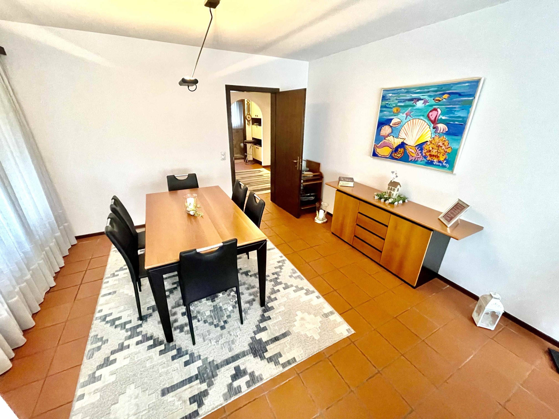 Esszimmer mit Holztisch und Terrakottaboden
