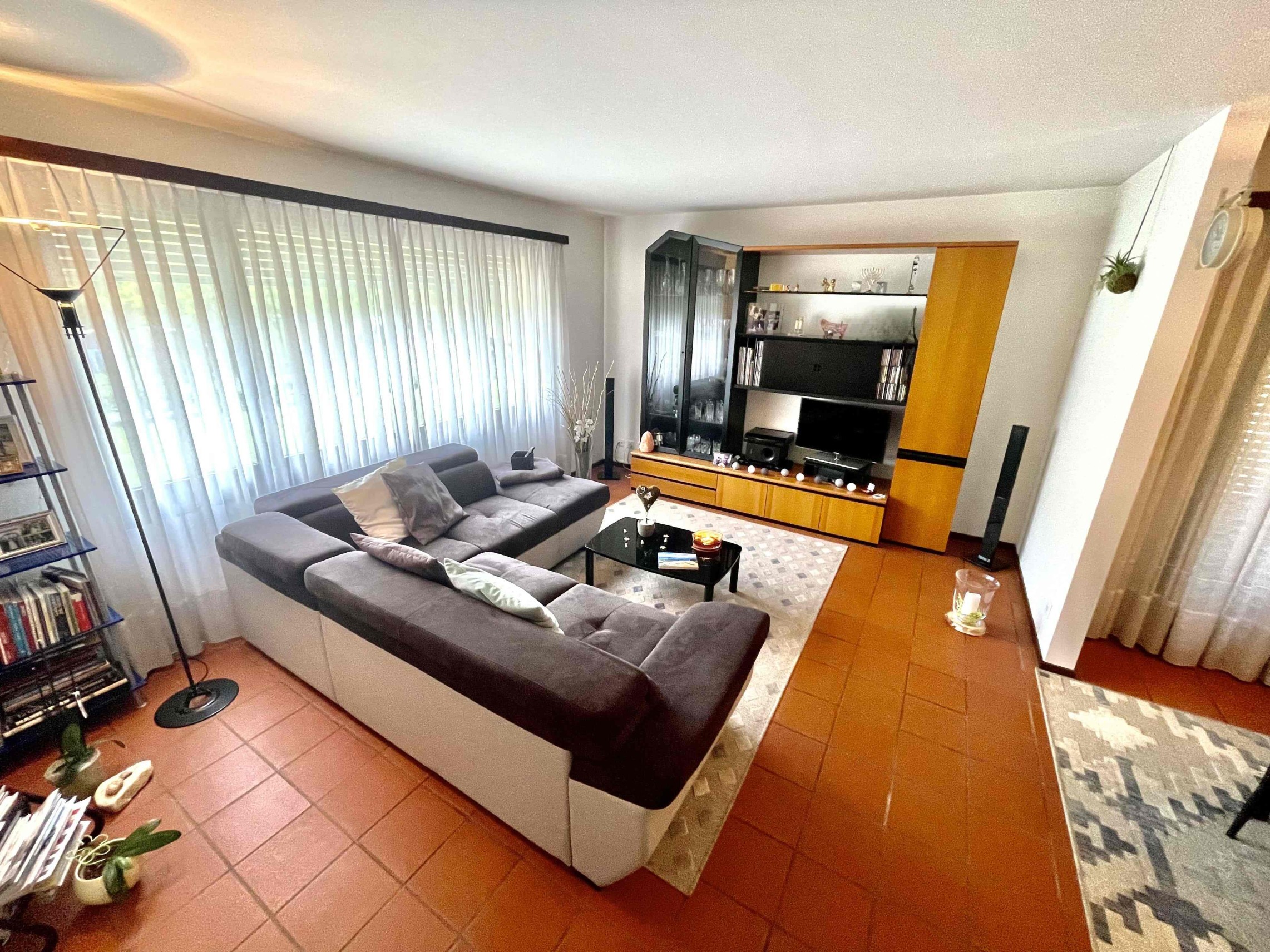 Wohnzimmer mit großer Fensterfront und Wohnwand