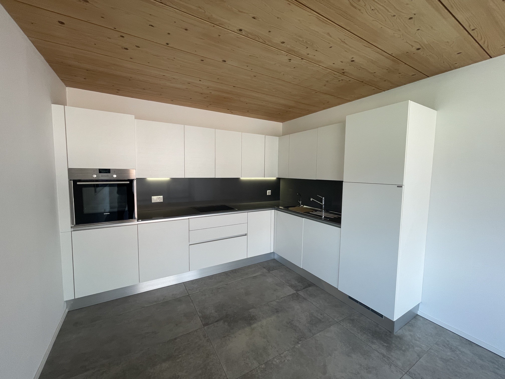 Moderne Einbauküche mit Holzdecke