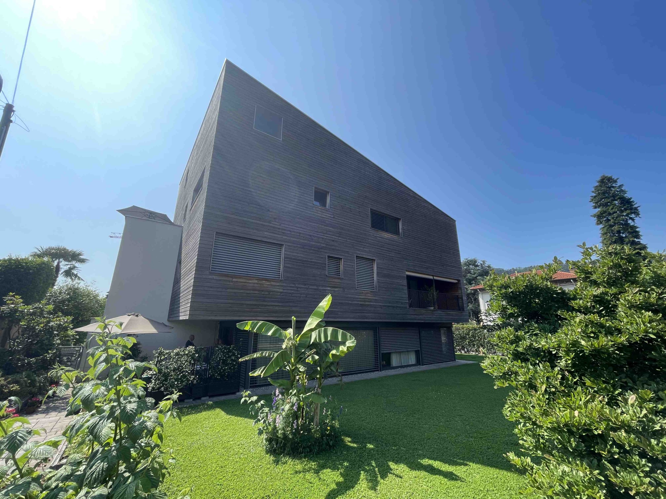 Modernes Haus mit spitz zulaufender Fassade und Garten