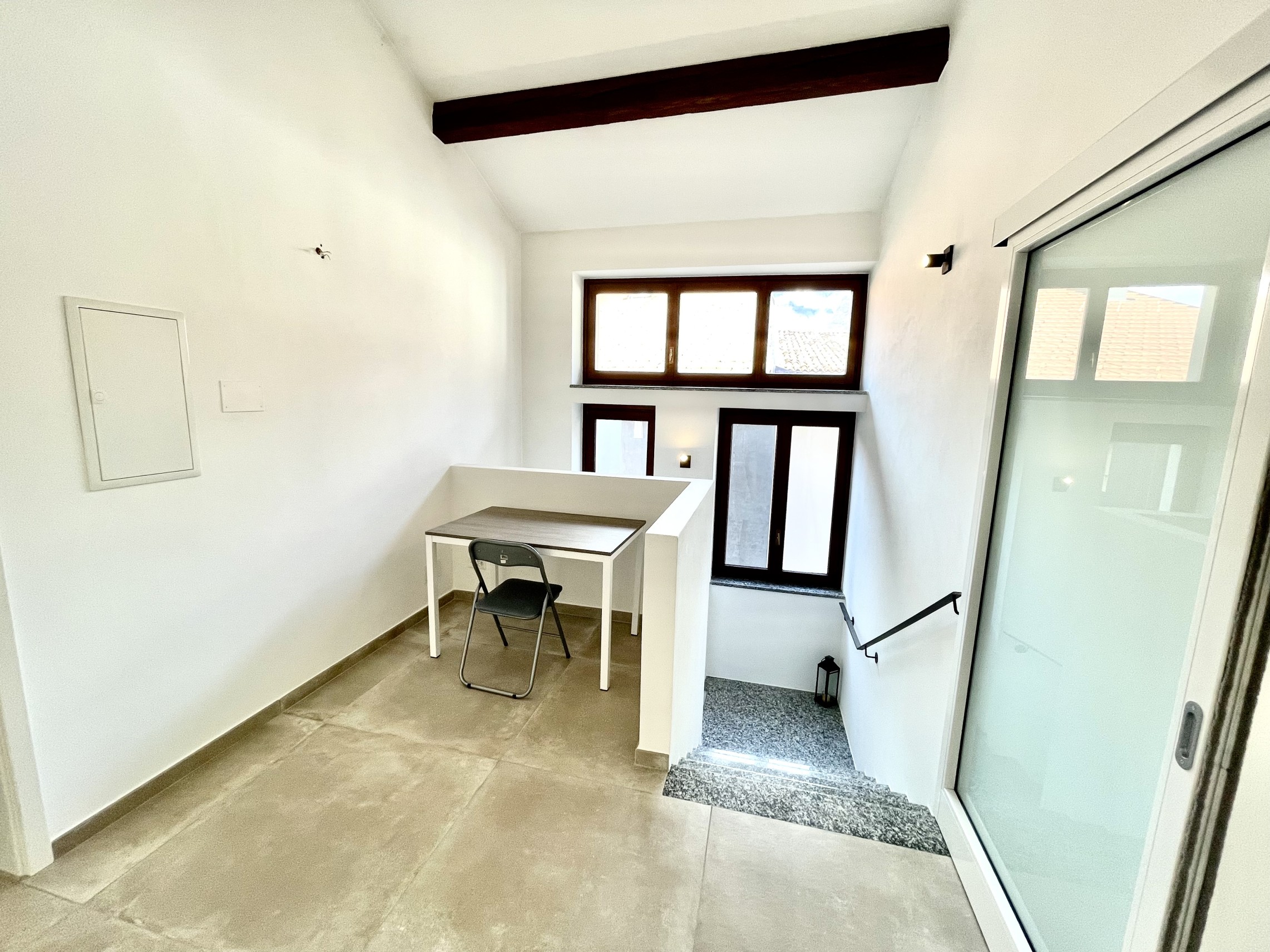 Heller Eingangsbereich mit Treppe und Arbeitsnische