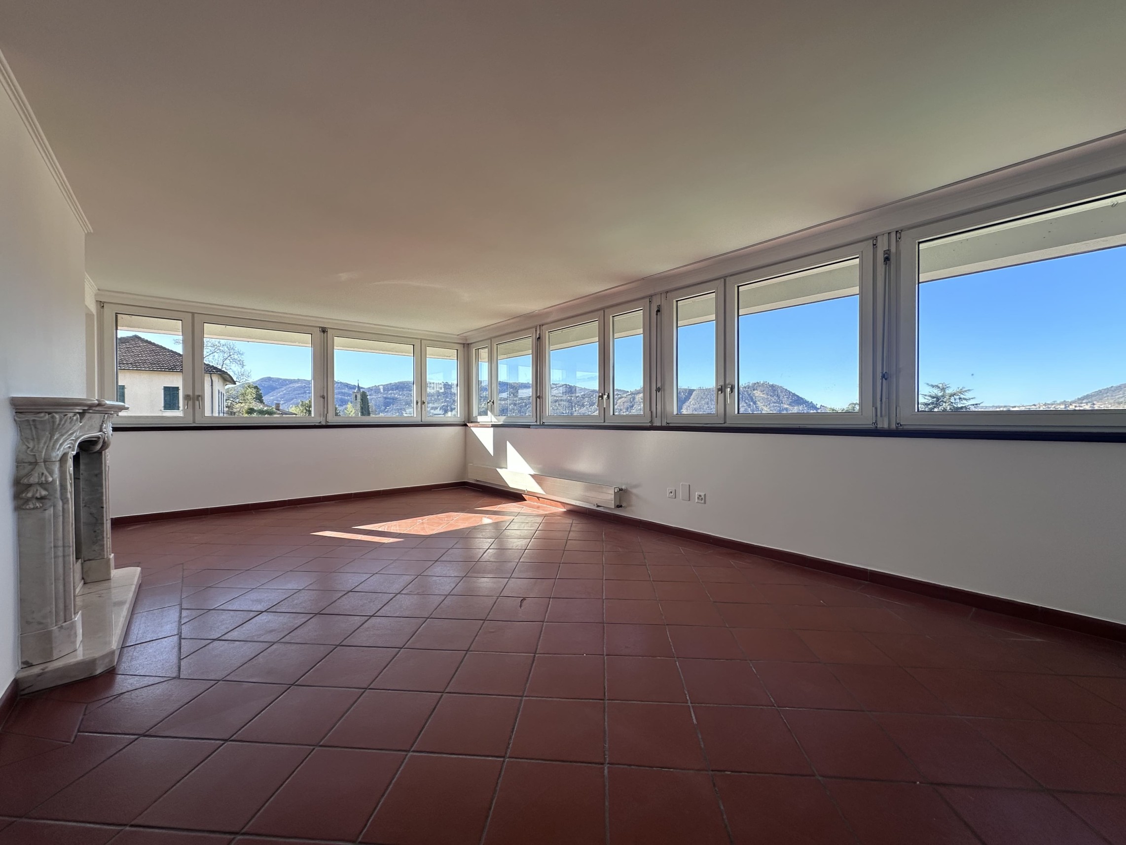 Heller Wohnraum mit Panoramafenstern und Terrassenkamin