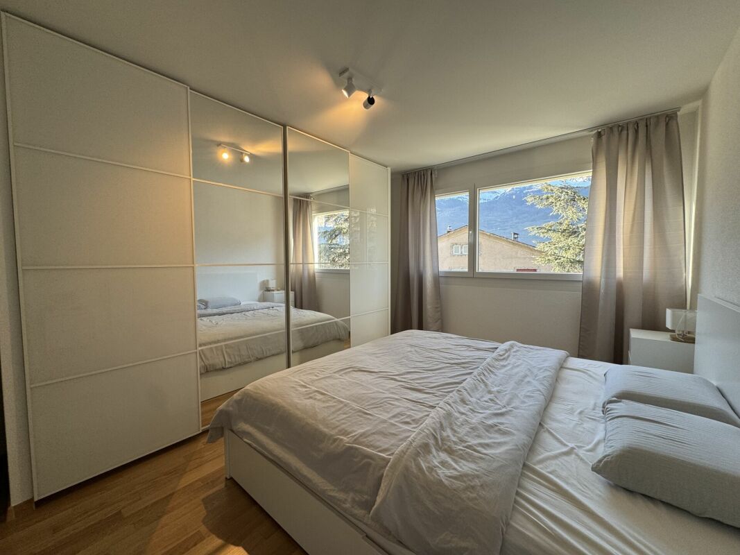 Modernes Schlafzimmer mit Einbauschrank und Bergblick