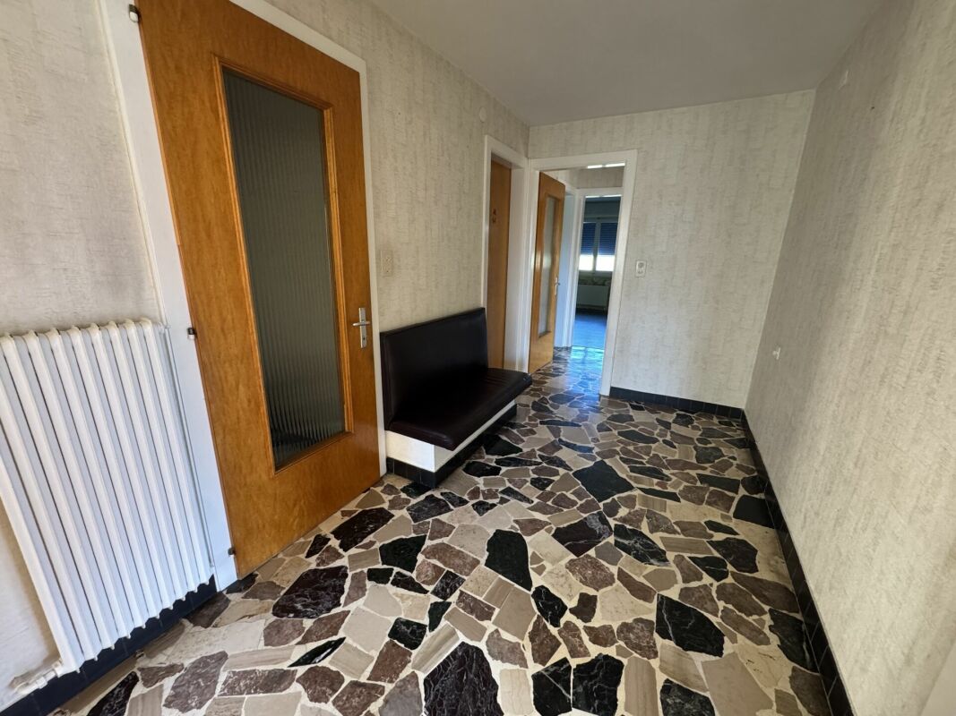 Flur mit Steinboden und Holztüren
