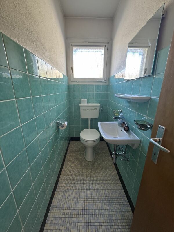 Kleines Gäste-WC mit türkisfarbenen Fliesen
