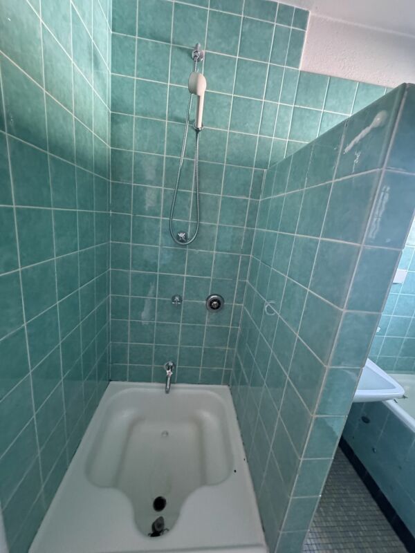 Bad mit türkisfarbenen Wandfliesen und Wanne