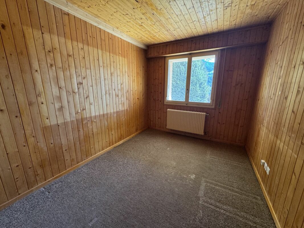 Leeres holzverkleidetes Zimmer mit Fenster