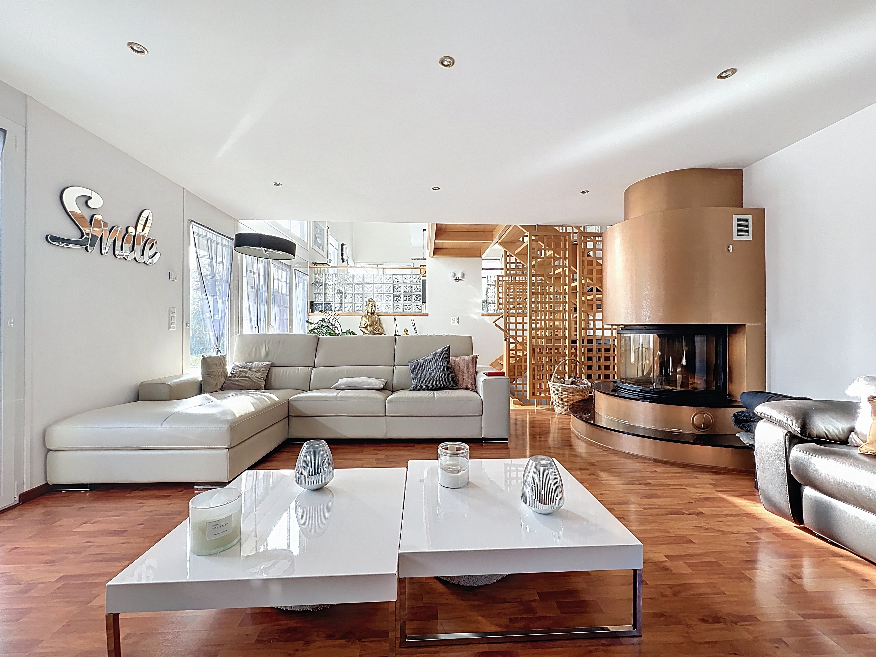 Helles Wohnzimmer mit Kamin und Holztreppe