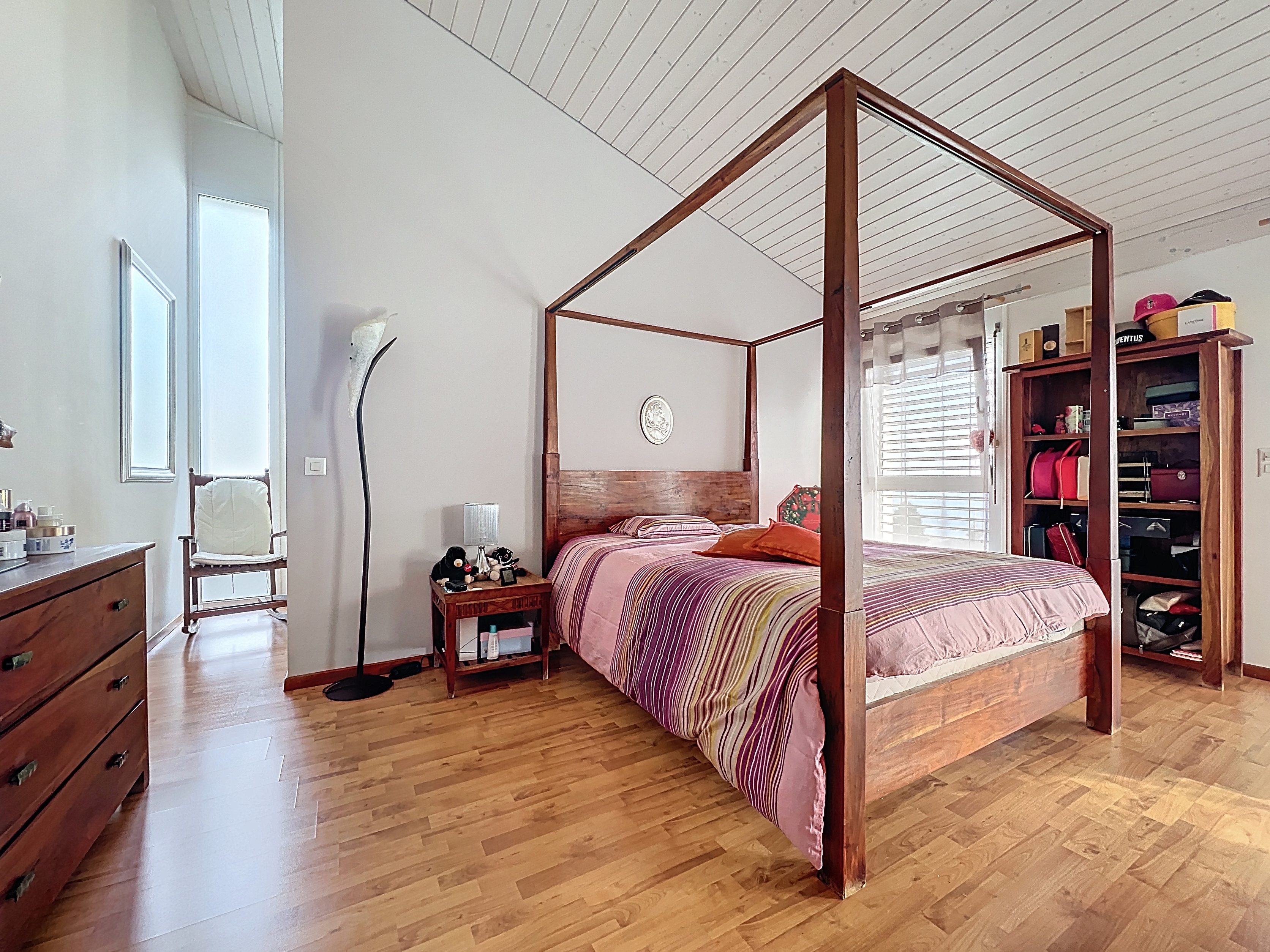Helles Schlafzimmer mit Himmelbett und Dachschräge