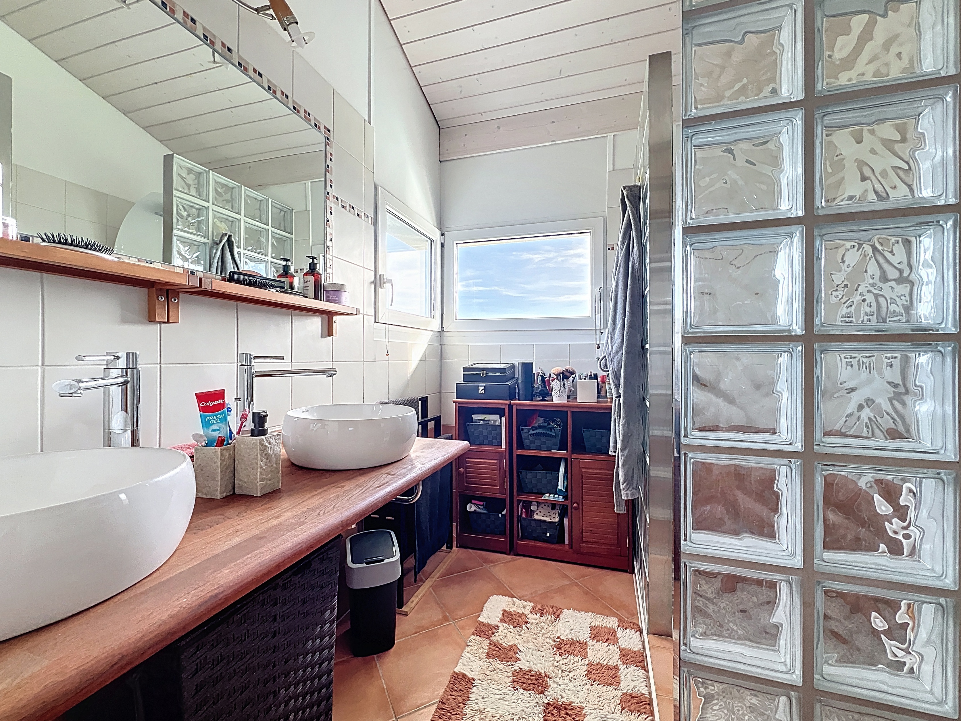 Modernes Badezimmer mit Doppelwaschplatz und Glasbausteinwand