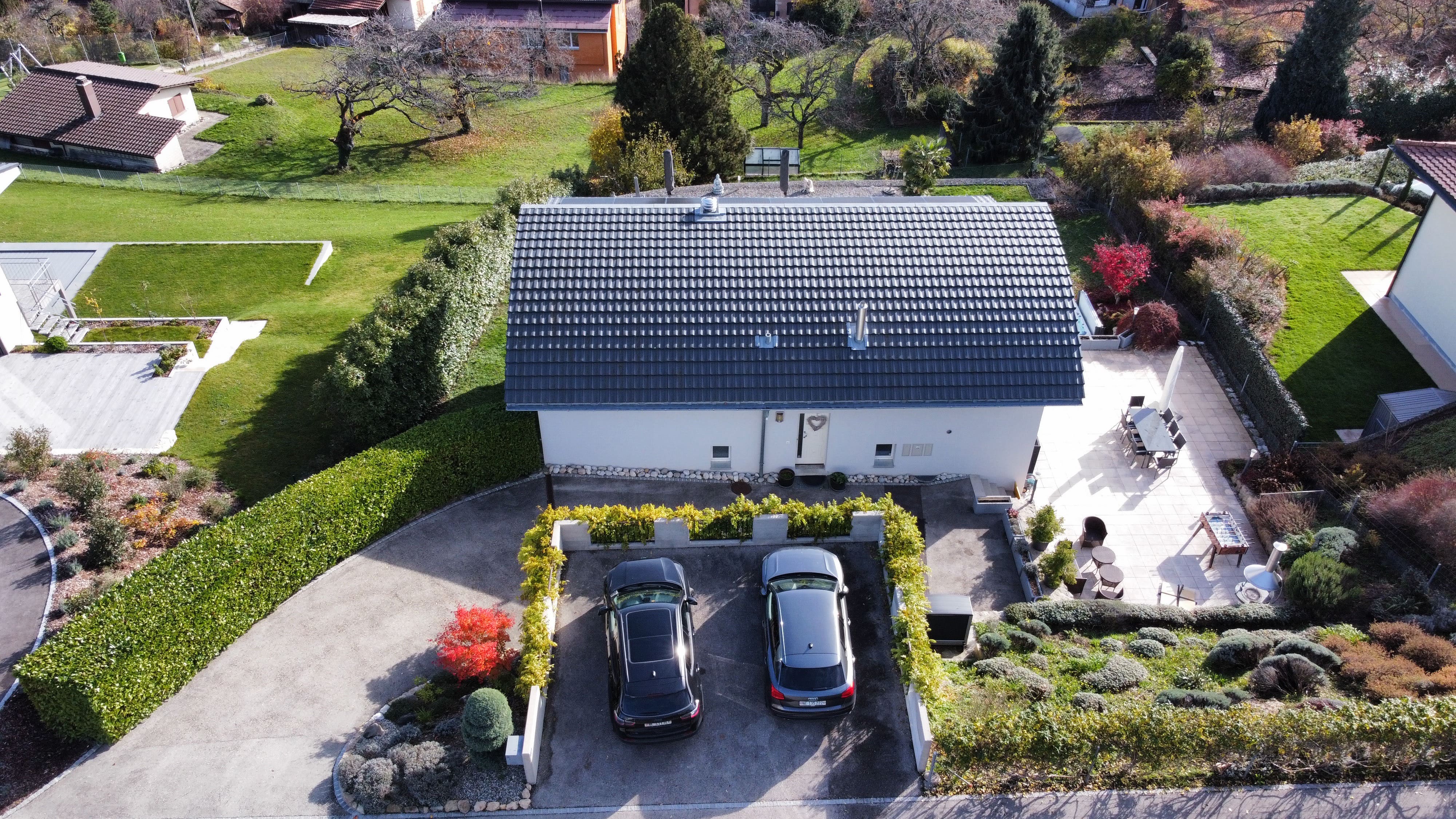 Luftaufnahme eines gepflegten Einfamilienhauses mit Garten und Doppelcarport