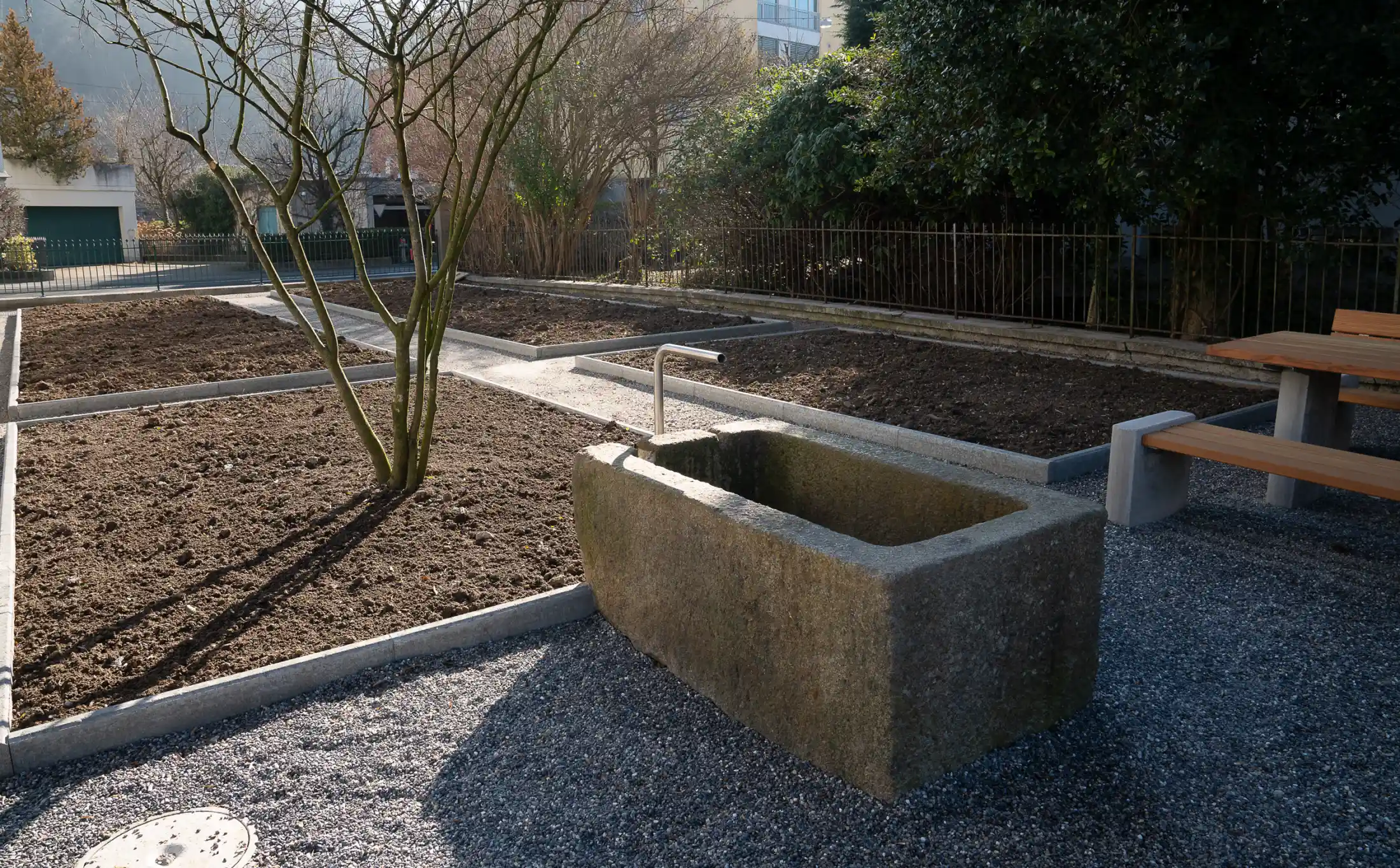 Gestalteter Außenbereich mit Pflanzbeeten und Brunnen