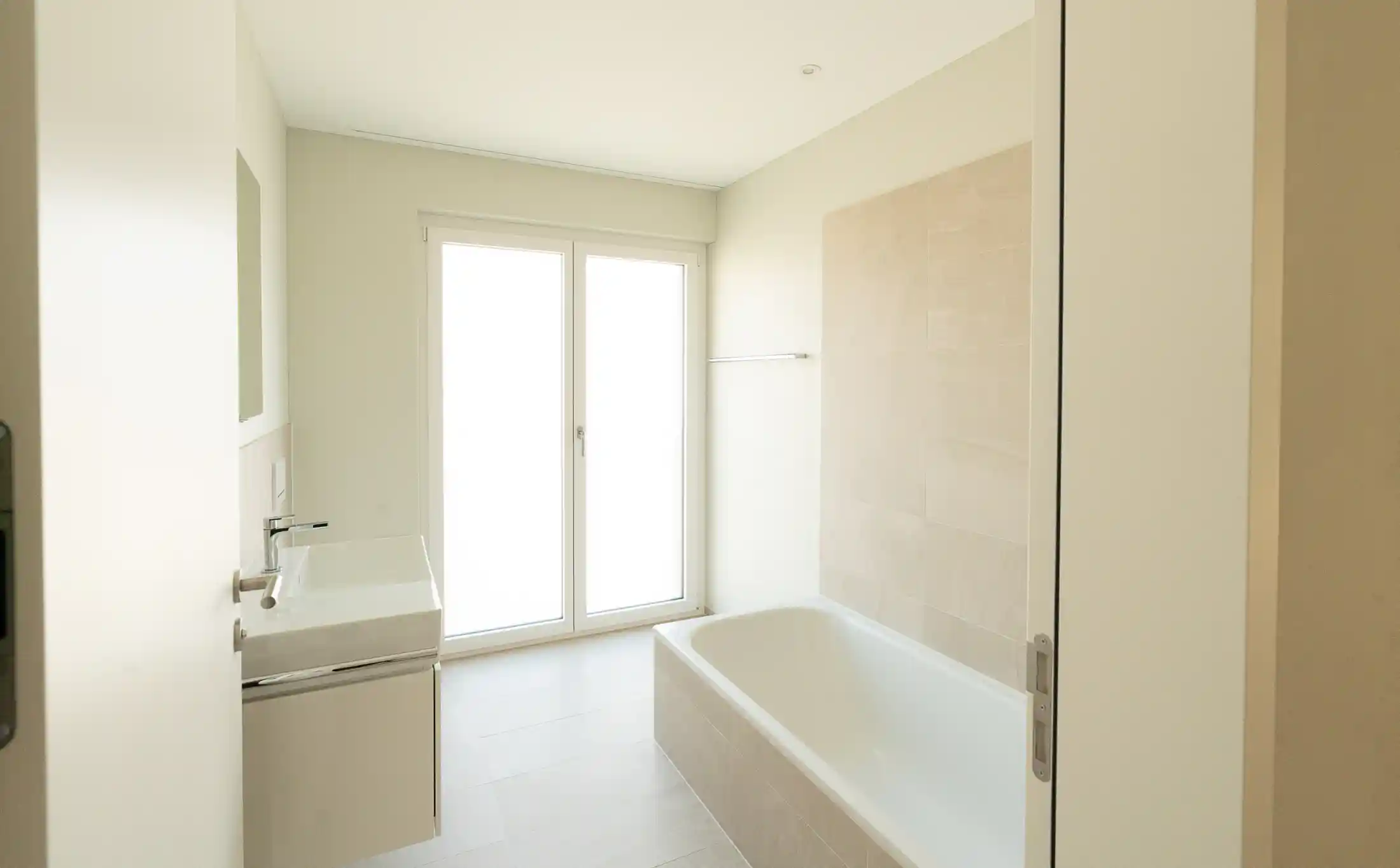 Helles, modernes Badezimmer mit Badewanne und Fensterfront