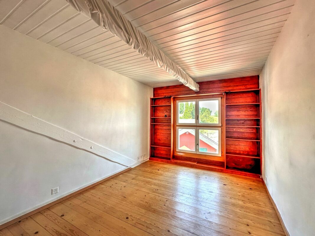 Heller leerer Raum mit Holzboden und Fensterwand