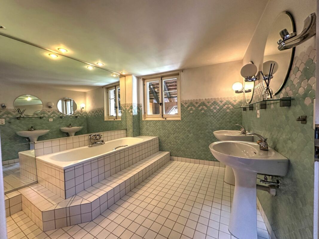 Großes Badezimmer mit Doppelwaschbecken und eingelassener Badewanne